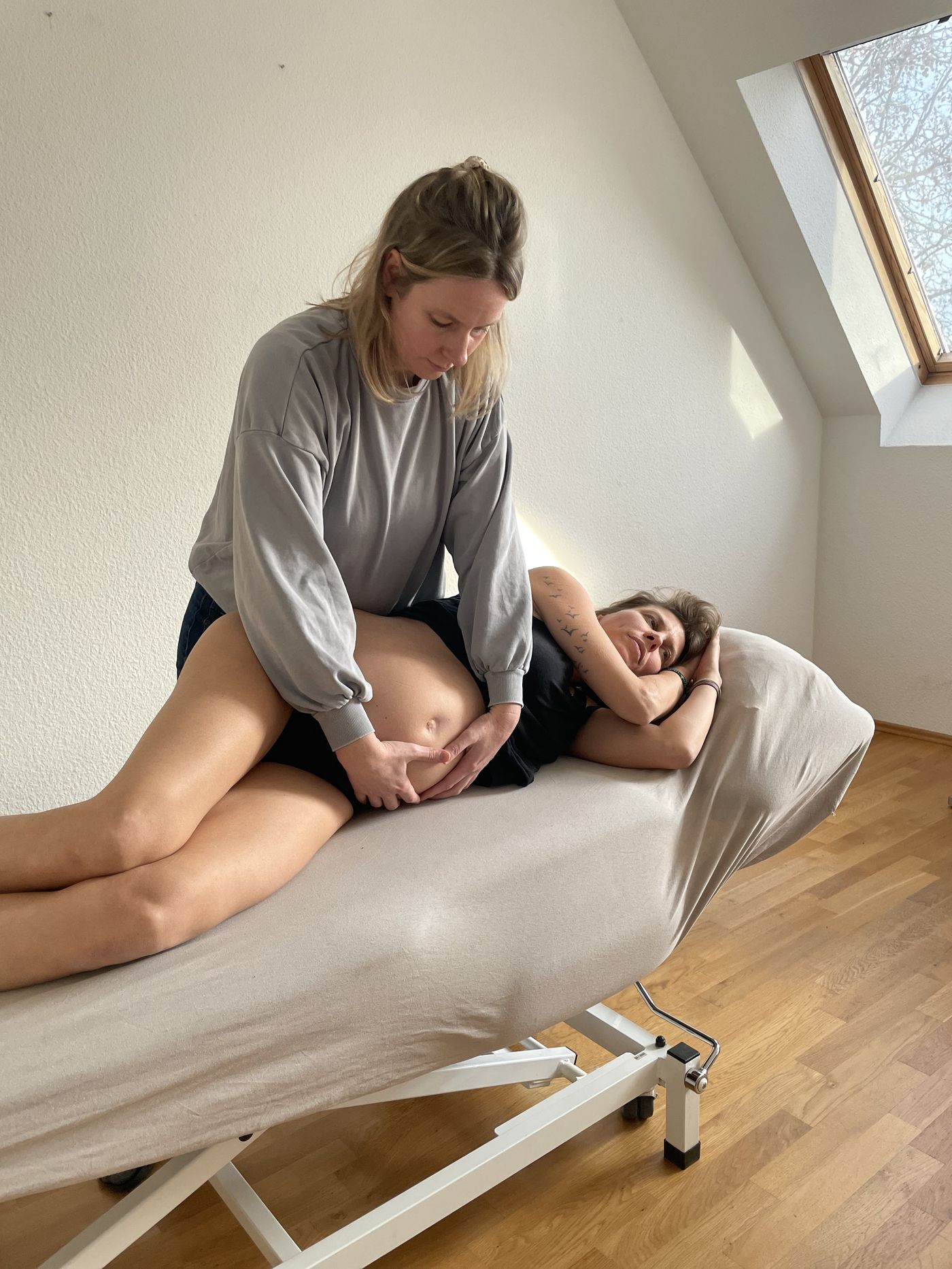 Osteopathische Behandlung einer Schwangeren in Seitenlage